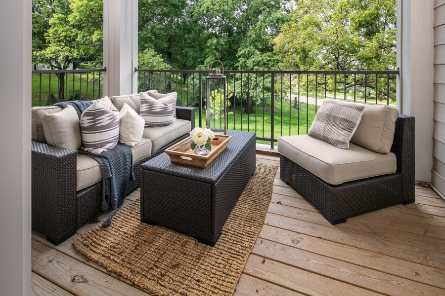 a porch with couches and a table on a wooden deck