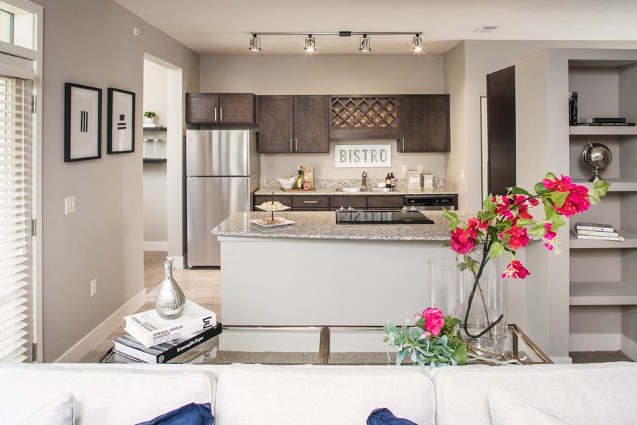 a living room with a kitchen and a table with flowers