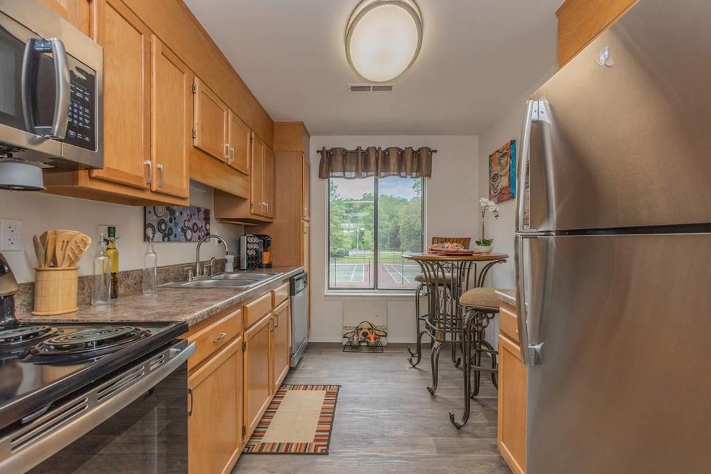 a kitchen with wooden cabinets and stainless steel appliances and a window