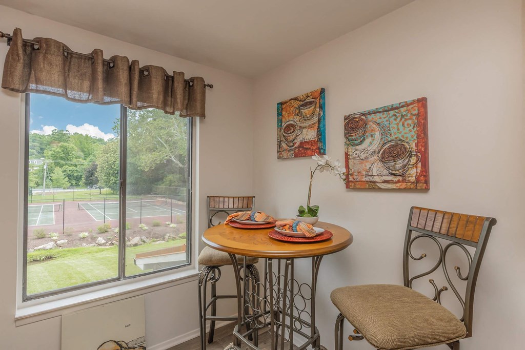 a small table with two chairs in front of a window