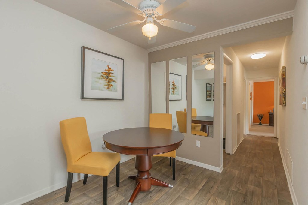 a dining room with a table and chairs and a ceiling fan