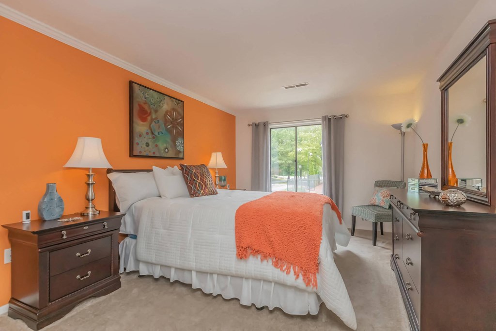 a bedroom with a bed and a dresser and a window