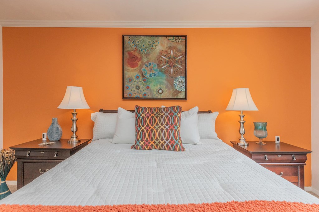 a bedroom with a large bed and a painting on the wall