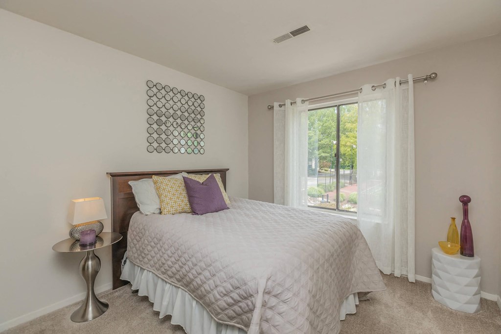 a bedroom with a large bed and a window