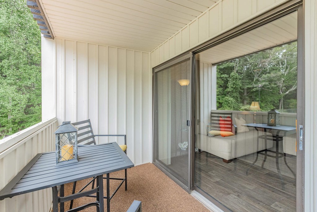 a porch with a table and chairs and a sliding glass door