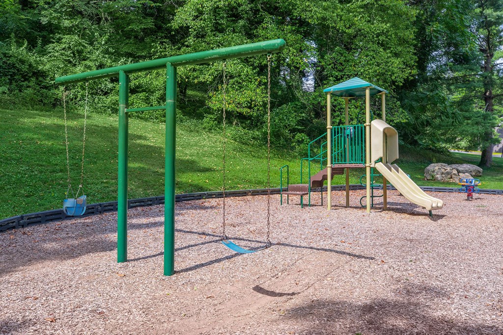 a swing set with a slide in a park