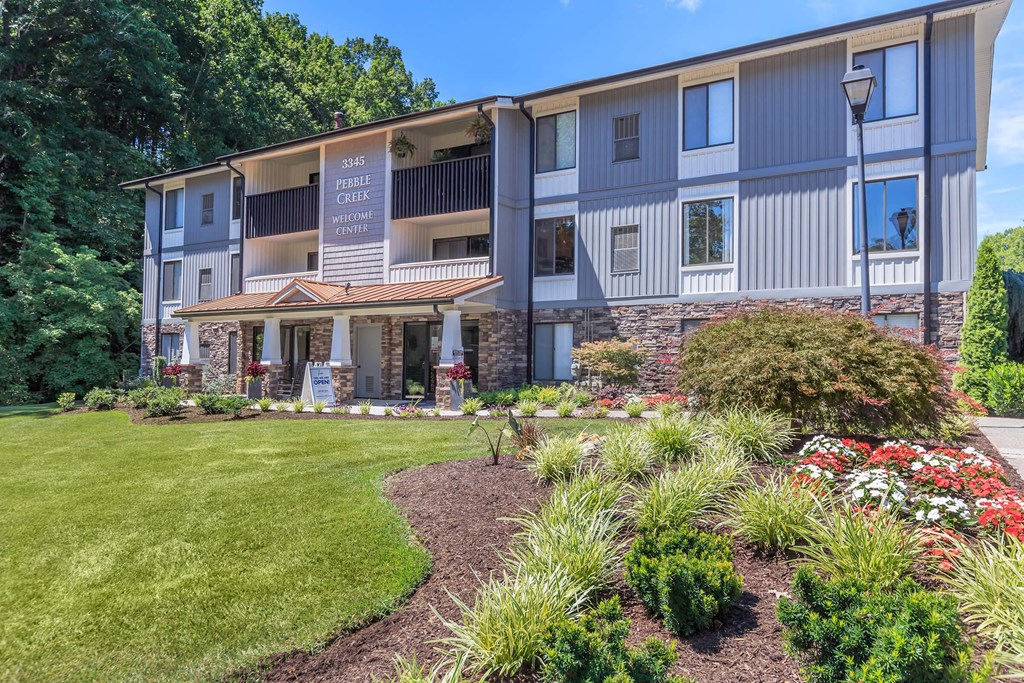 a building with a lawn and a garden in front of it