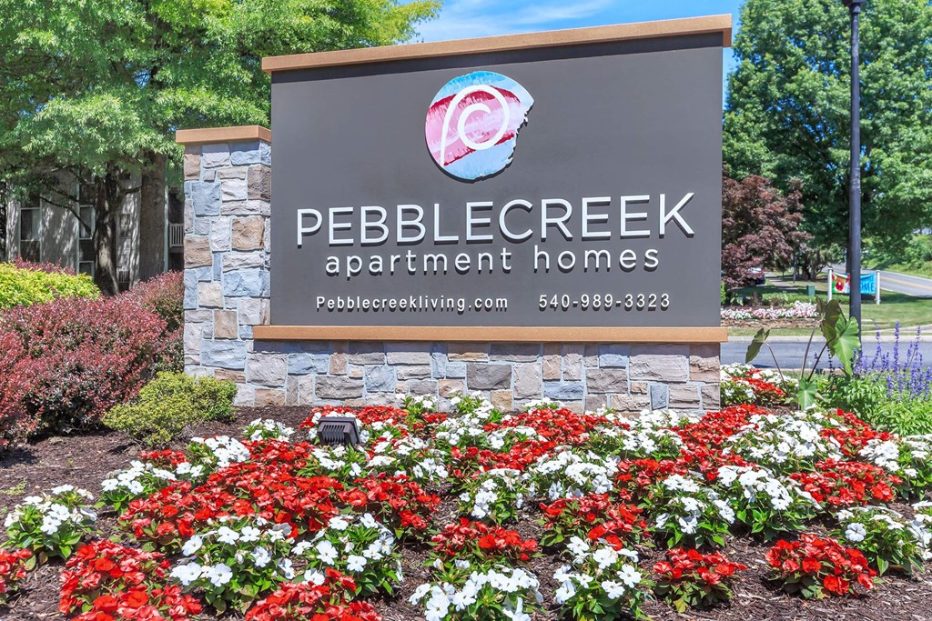 a sign apartment homes with red and white flowers