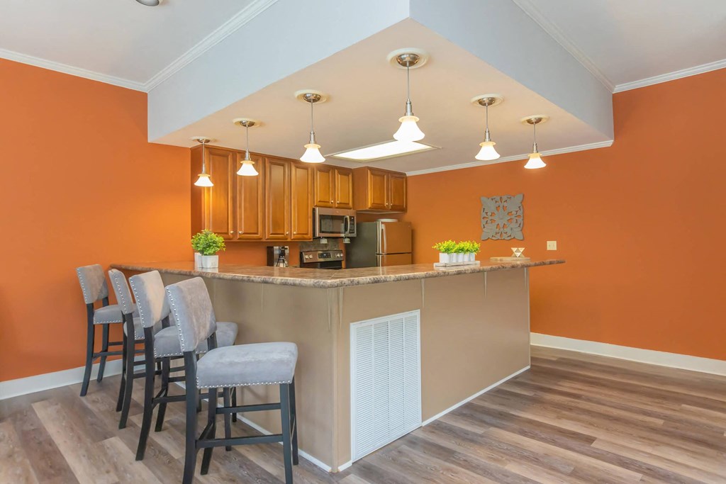 a kitchen with a bar with chairs and a counter