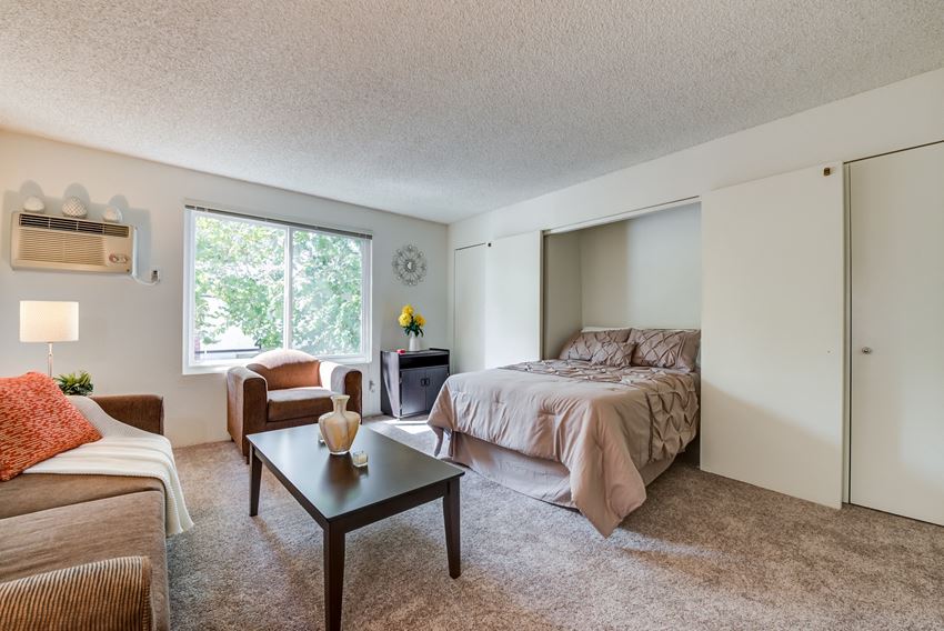 a bedroom with a bed and a couch and a coffee table