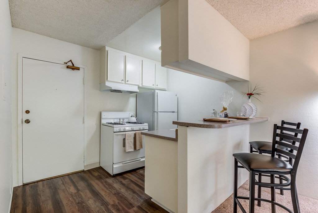 a kitchen with a bar and a refrigerator and a stove