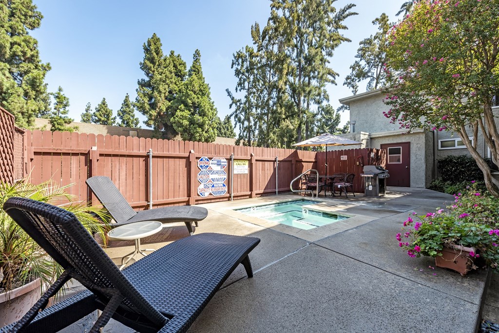 a backyard with a pool and patio with chairs and a table