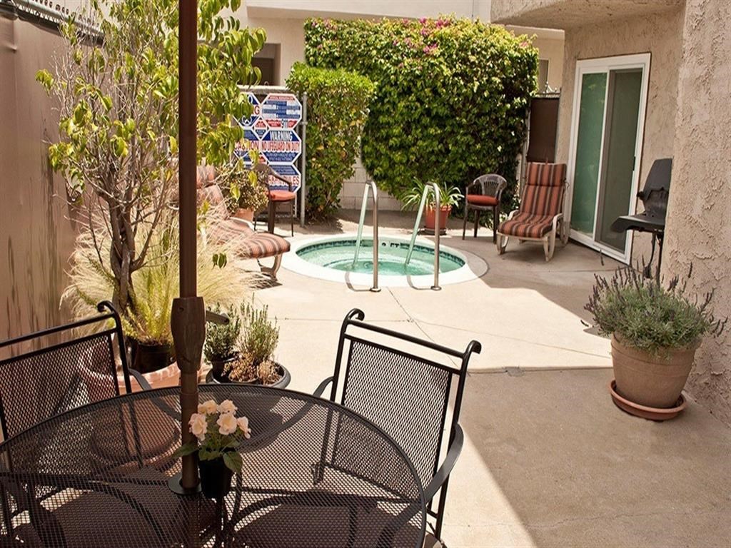 a patio with a table and chairs and a swimming pool