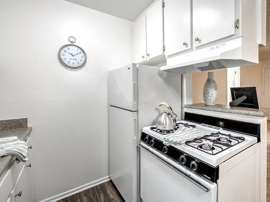 a kitchen with white appliances and a clock on the wall