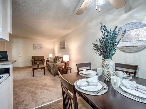 a dining room table with a vase of flowers