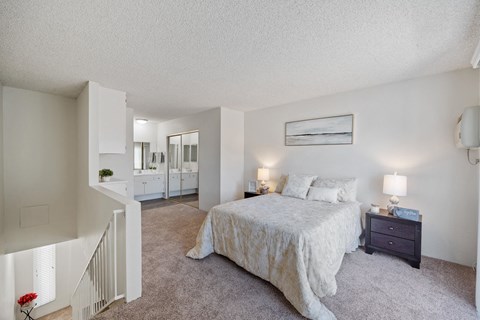 a bedroom with a bed and a staircase