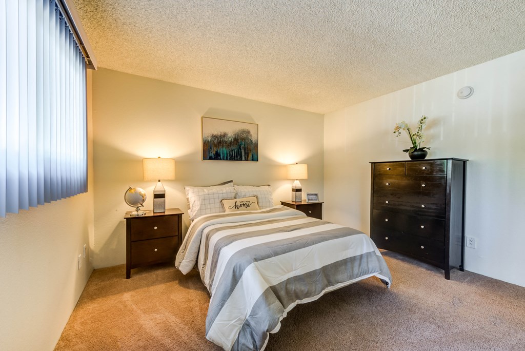 a bedroom with a bed and a dresser and a window