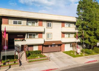 Areal photo of the Ridgeview Apartments in Northridge, showcasing the curb, entrance, and the gated parking garage