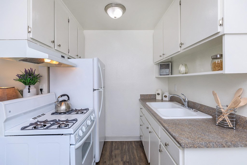 a kitchen with white appliances and granite counter tops
