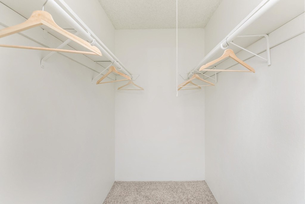 a white room with two hanging clothes racks on the wall