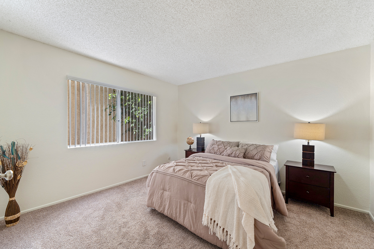Spacious bedroom with mirrored closet doors, updated carpets and a ton of natural light at the enclave apartments in studio city, CA.