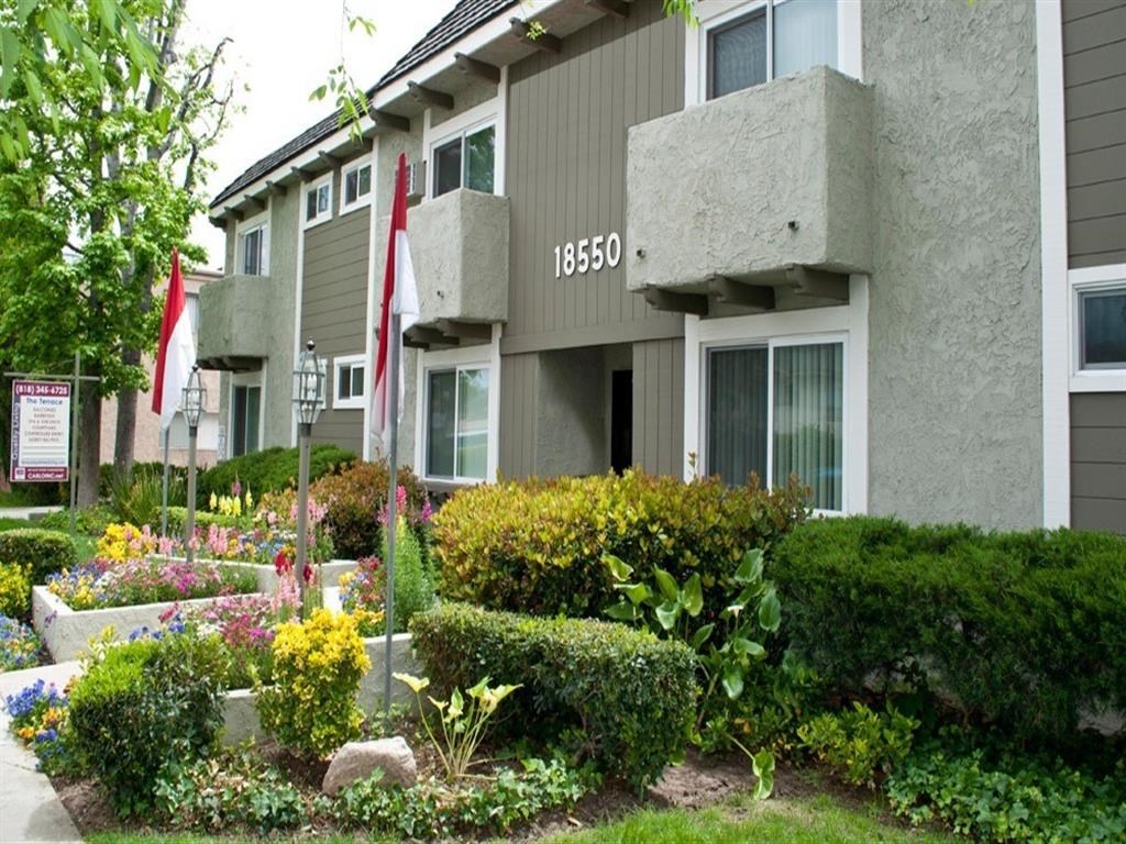 an apartment building with a garden in front of it