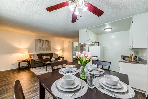 a living room with a dining room table and a ceiling fan