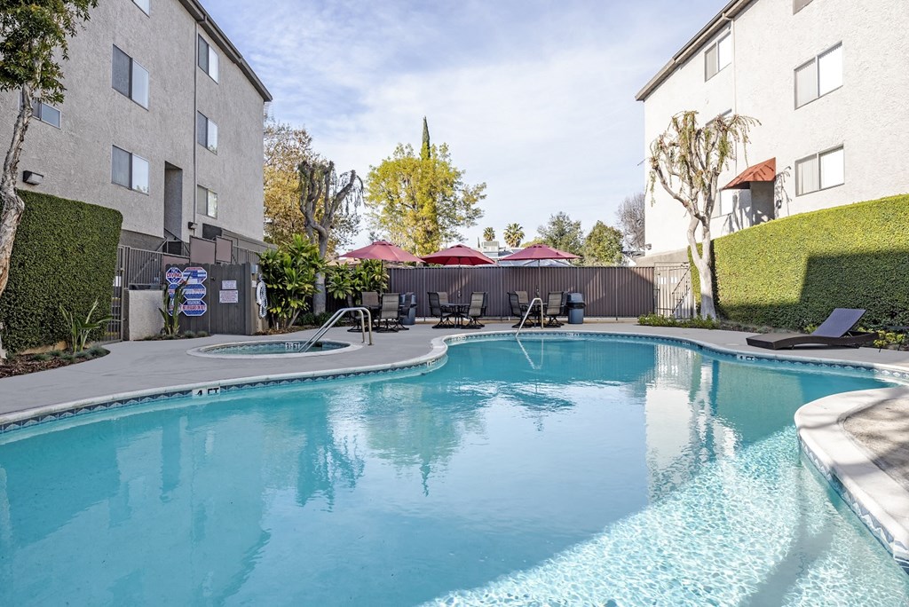 our apartments have a large resort style pool with chairs and umbrellas