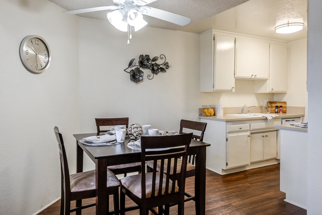 a dining area with a table and chairs and a kitchen