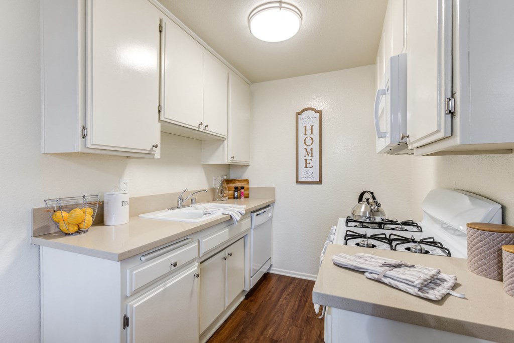 a kitchen with white cabinets and a stove and a sink