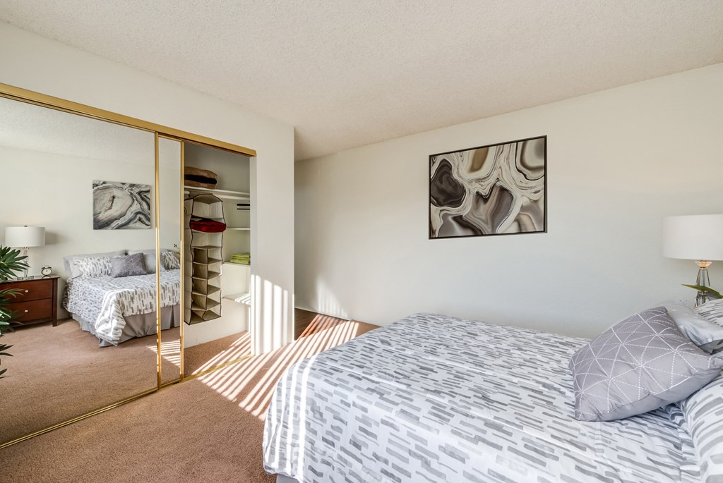 a bedroom with a bed and a closet with a mirror