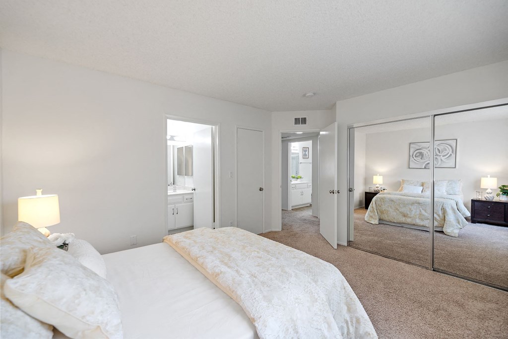 a bedroom with a large bed and a mirror