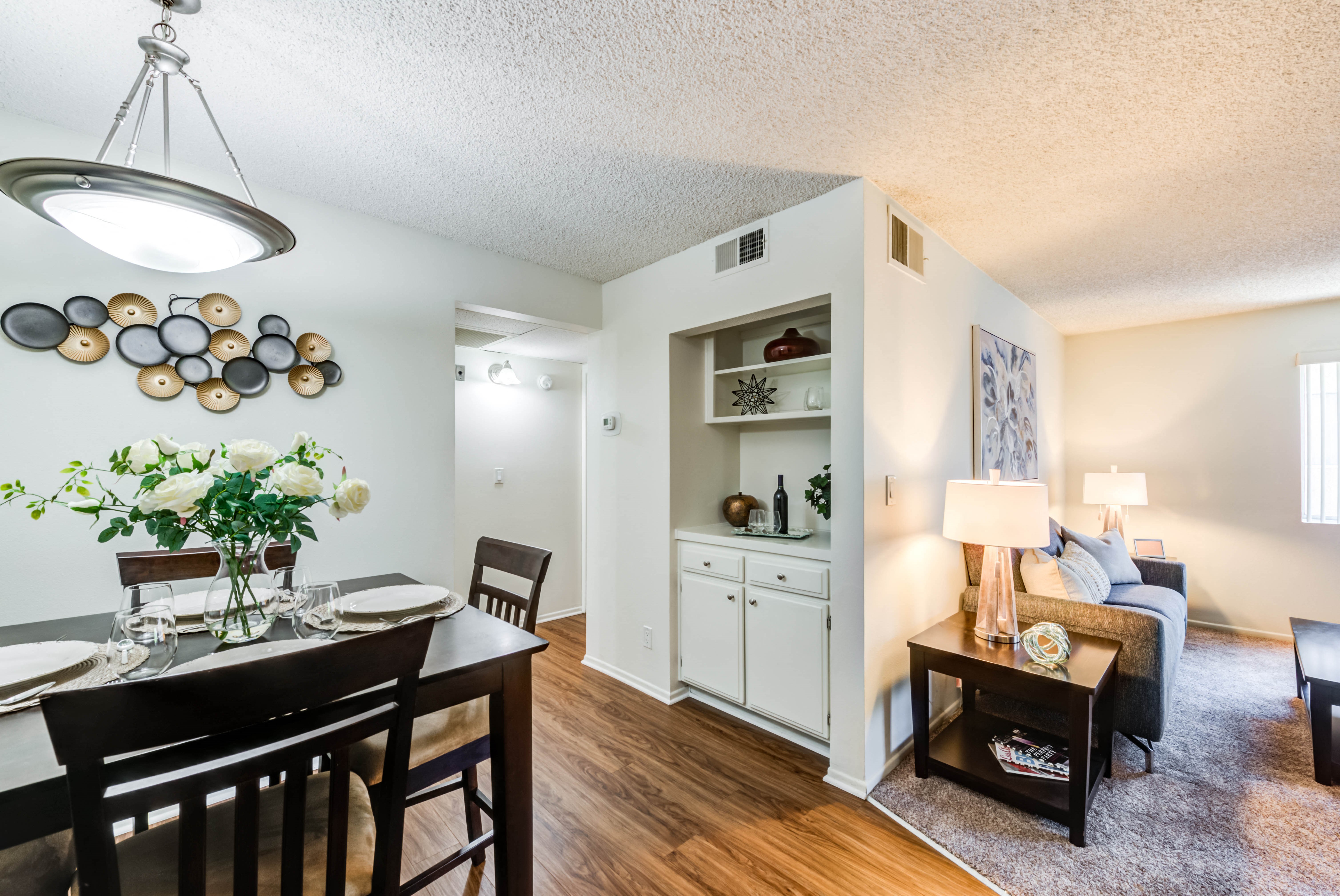 the view of a living room and dining room with a table and chairs