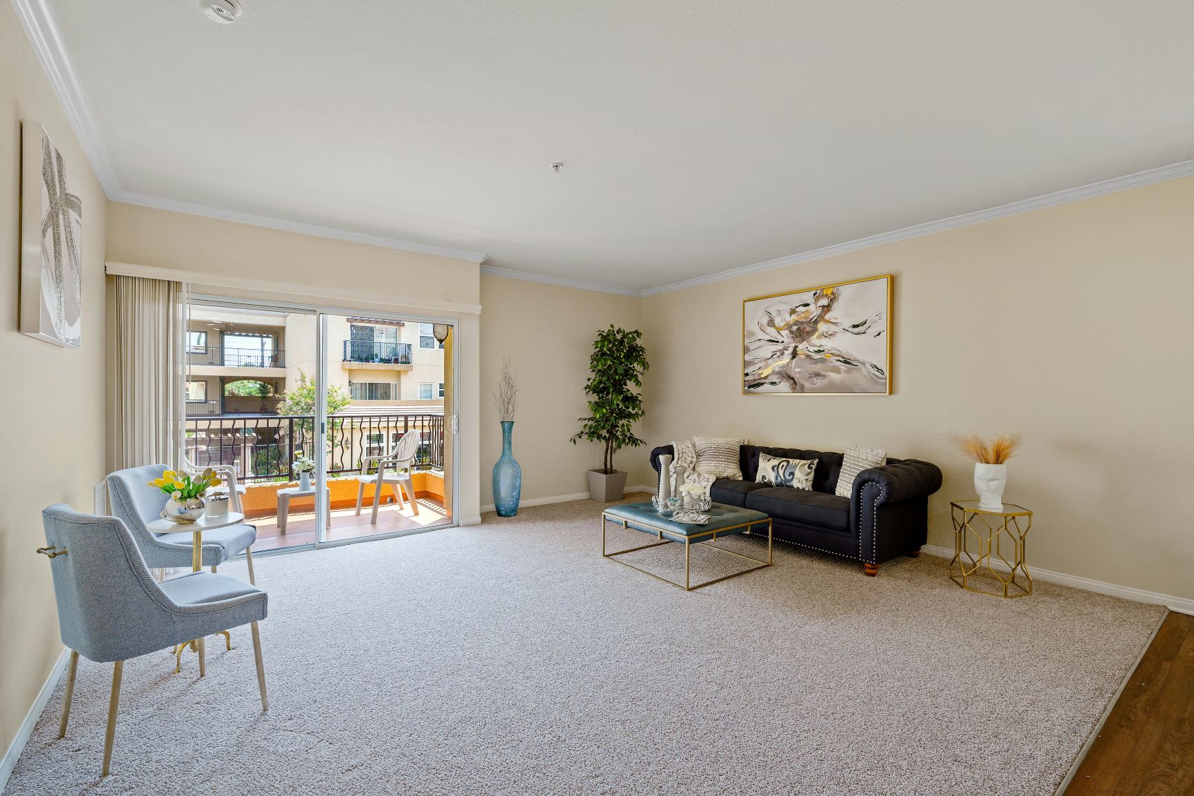 a living room with a couch and chairs and a balcony