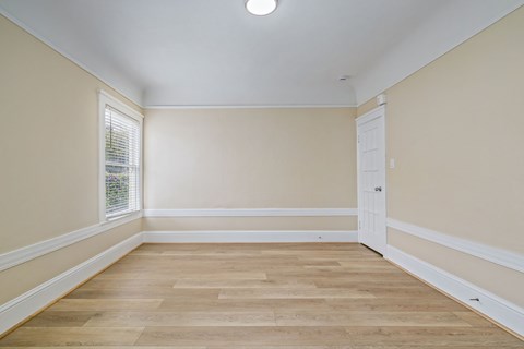 A room with wooden flooring and white trim.