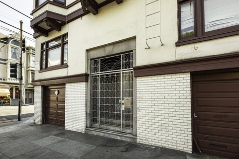 A white building with a brown door and a window.