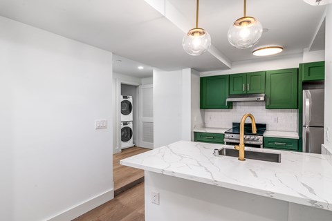 A kitchen with green cabinets and a white countertop.