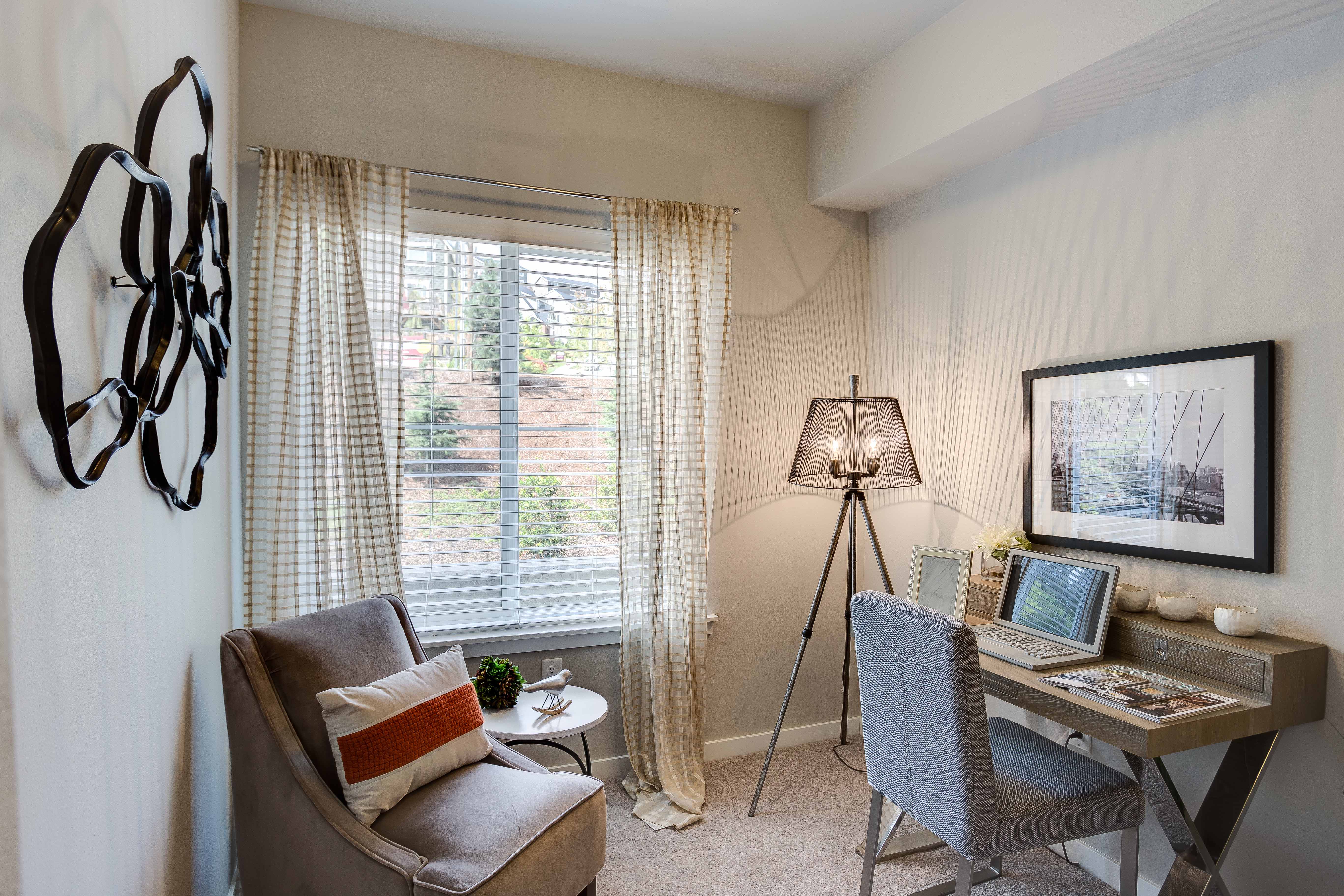 a living room with a couch and a desk with a laptop