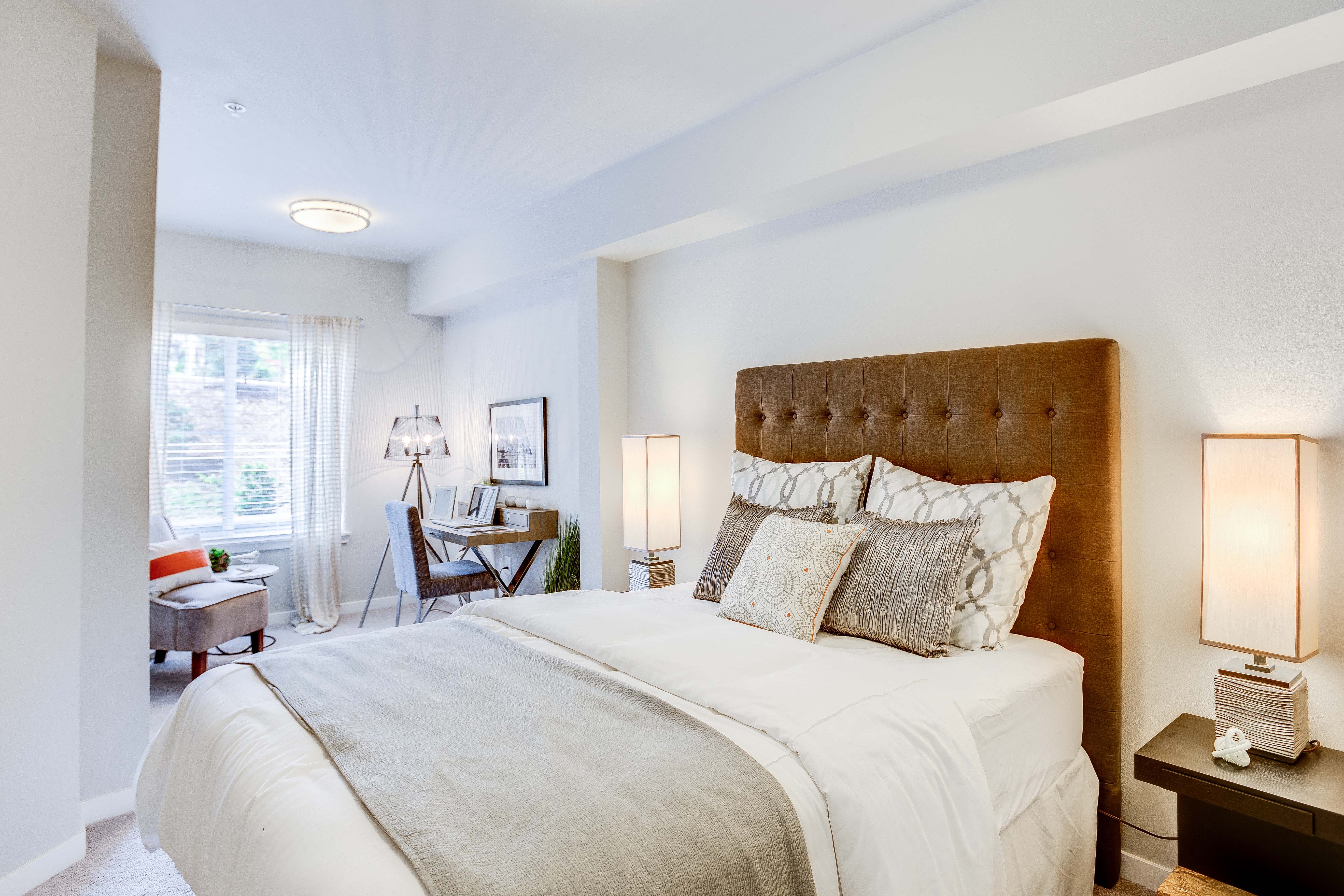 a bedroom with a large bed and a desk with a chair