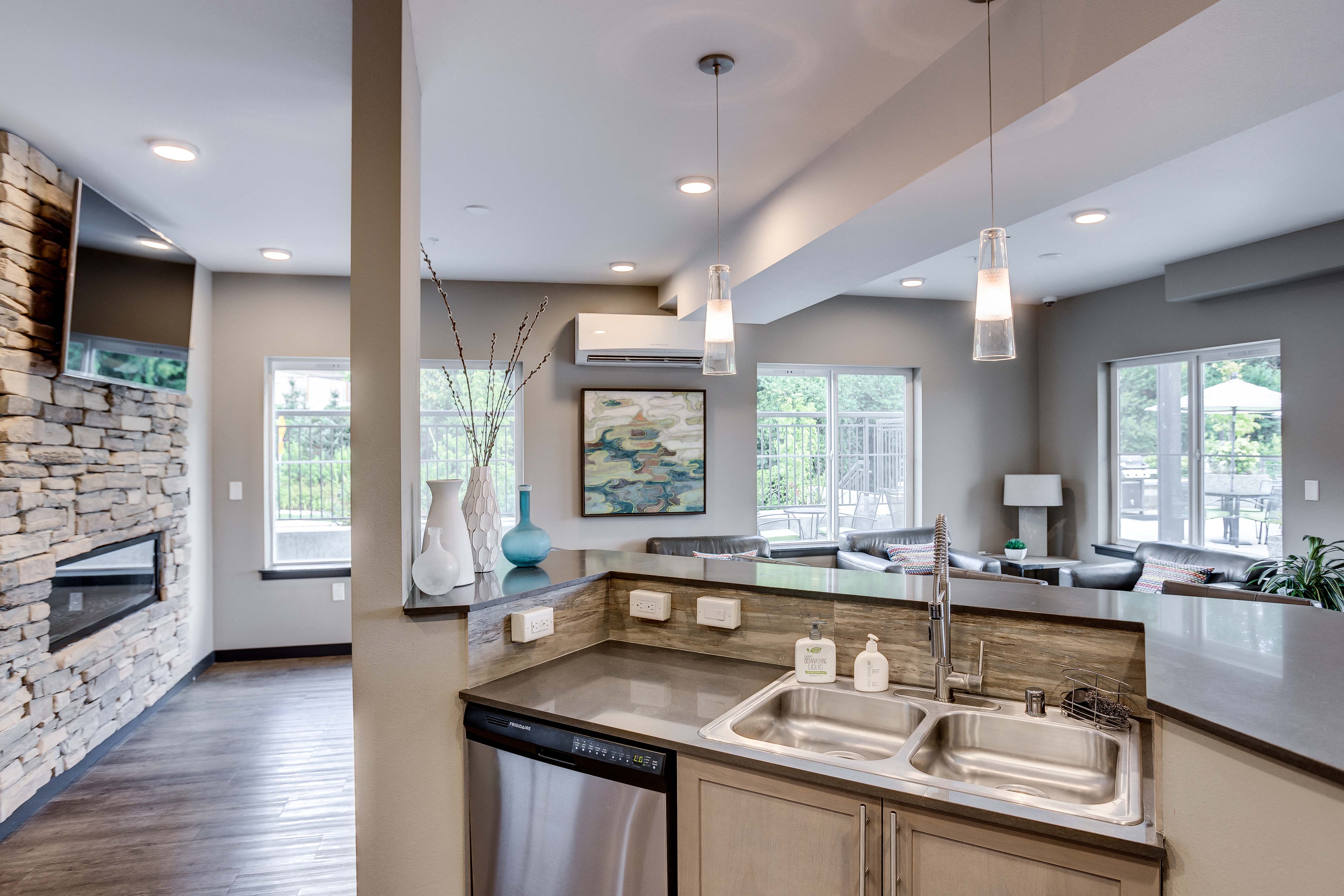 an open kitchen and living room with a stone fireplace