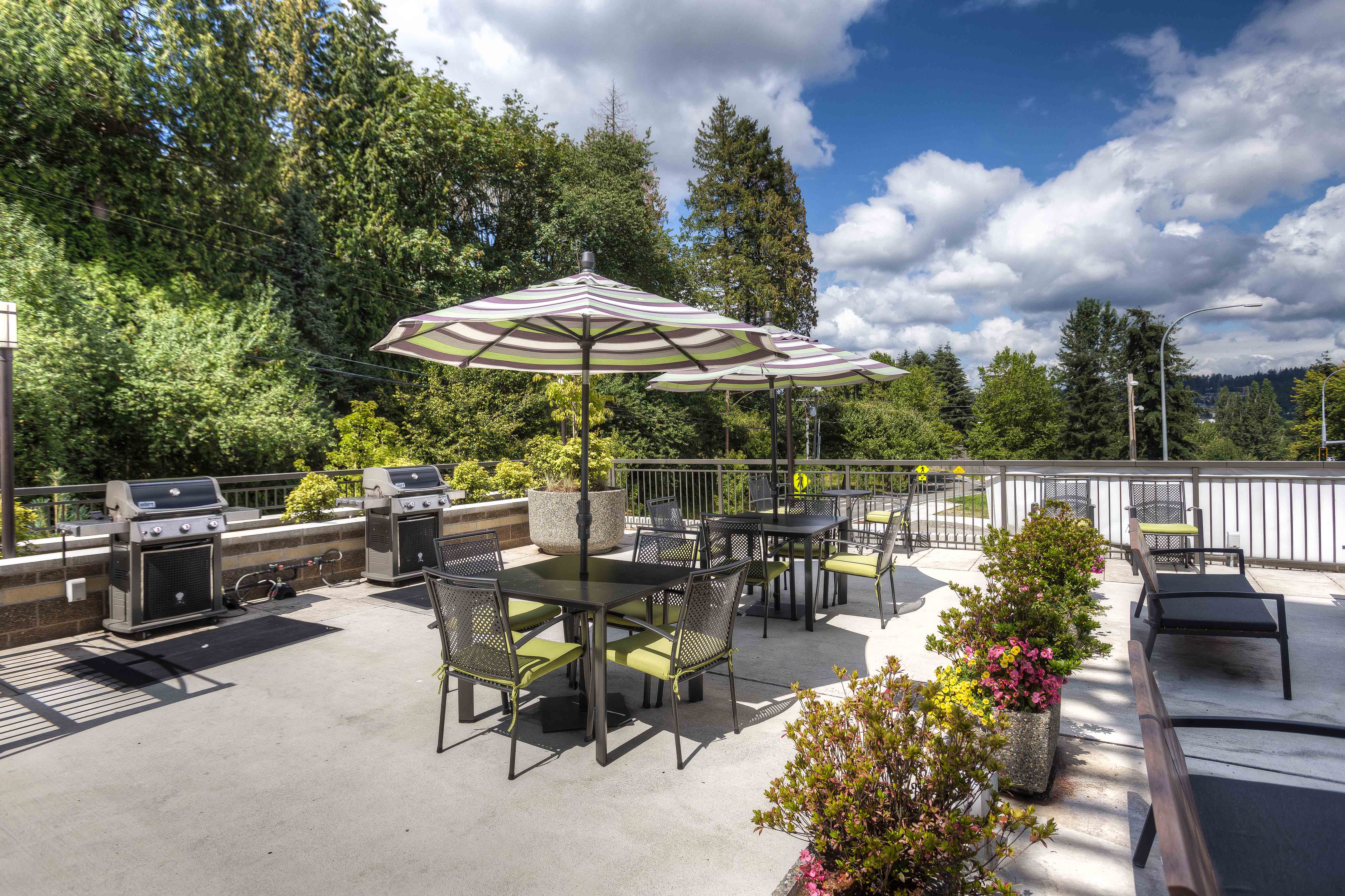 a patio with tables and chairs and an umbrella
