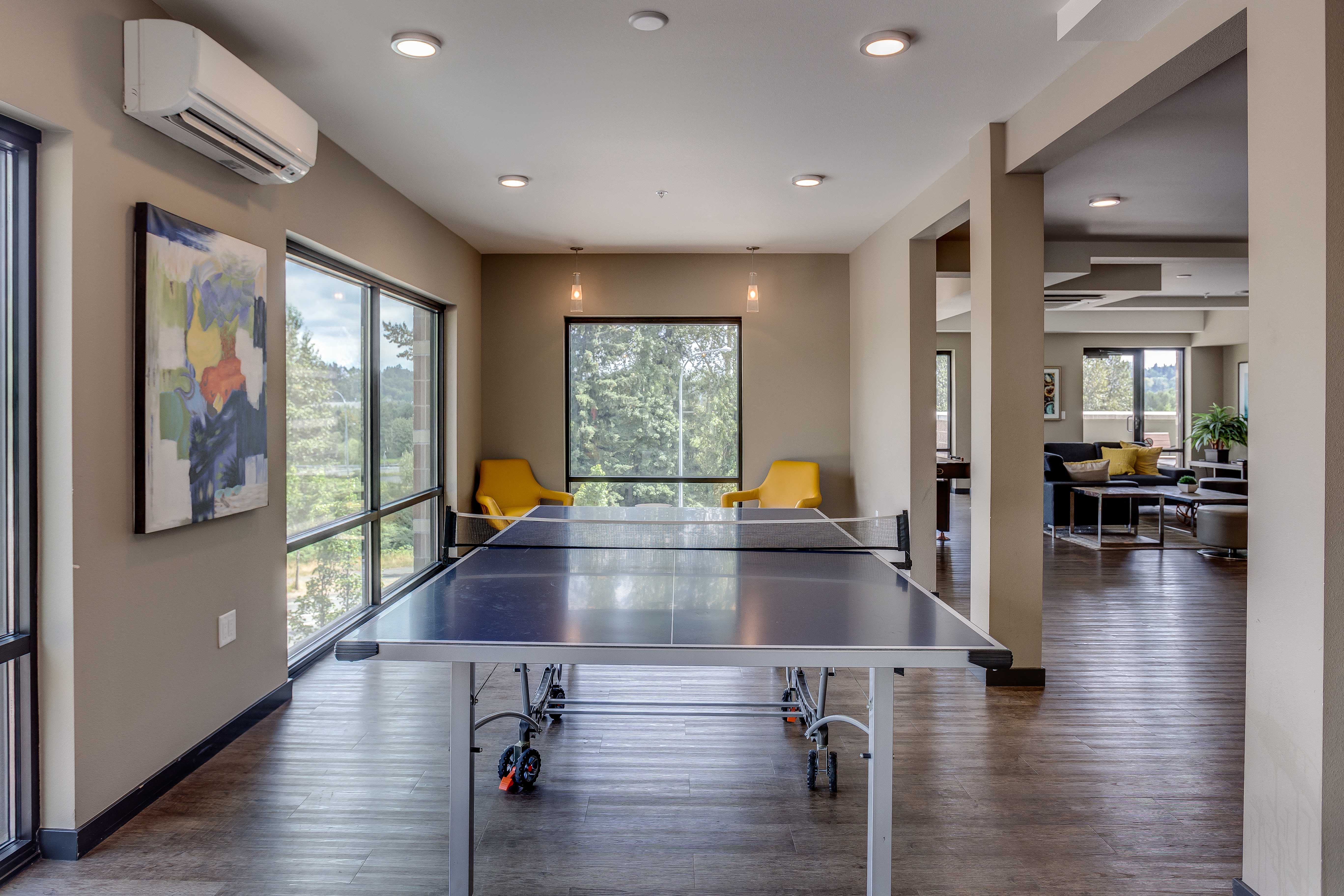 a ping pong table sits in the center of a room with windows and a