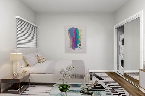 A modern living room with a white couch, a painting on the wall, and a washing machine in the laundry area.