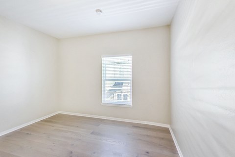 A room with a window and wooden flooring.
