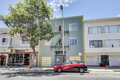 a red car parked in front of a building