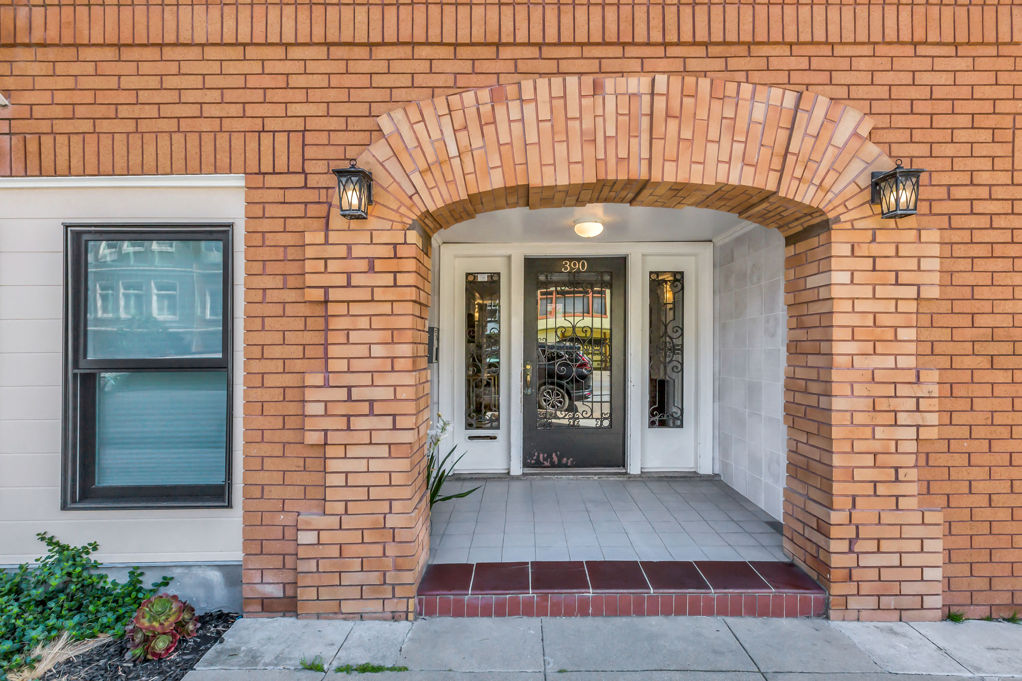 A red brick building with a white door and a window.