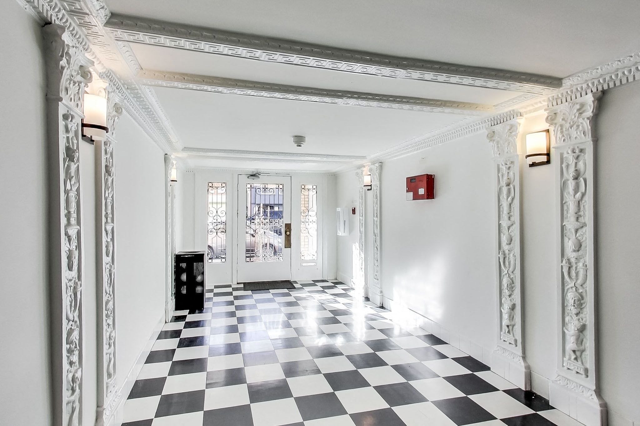 A long hallway with a black and white checkered floor.