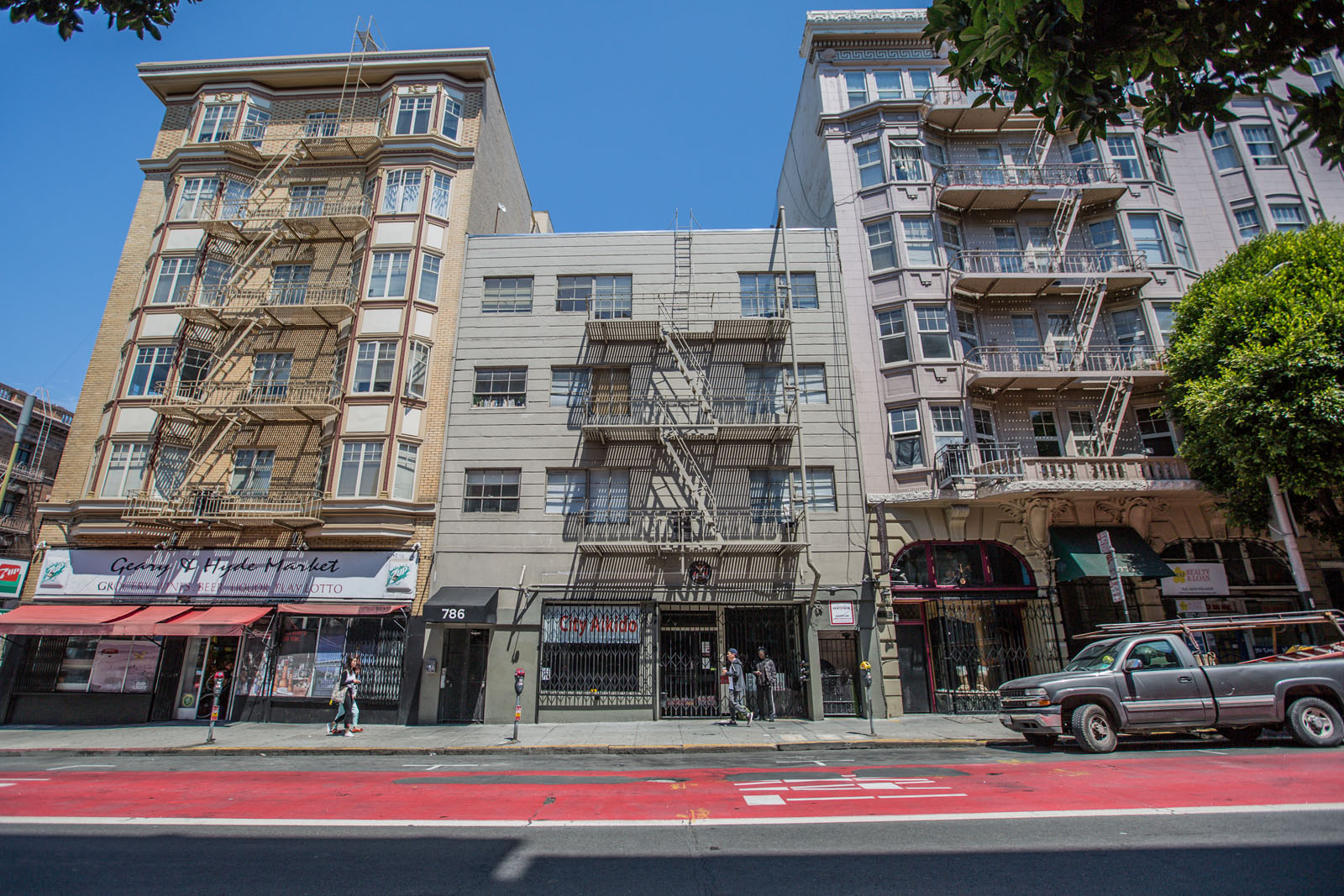 A street view of a city with buildings, a pedestrian, and a car.