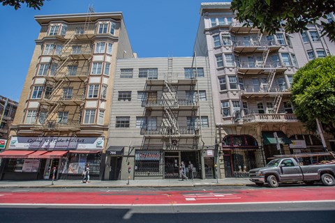 A street view of a city with buildings, a pedestrian, and a car.
