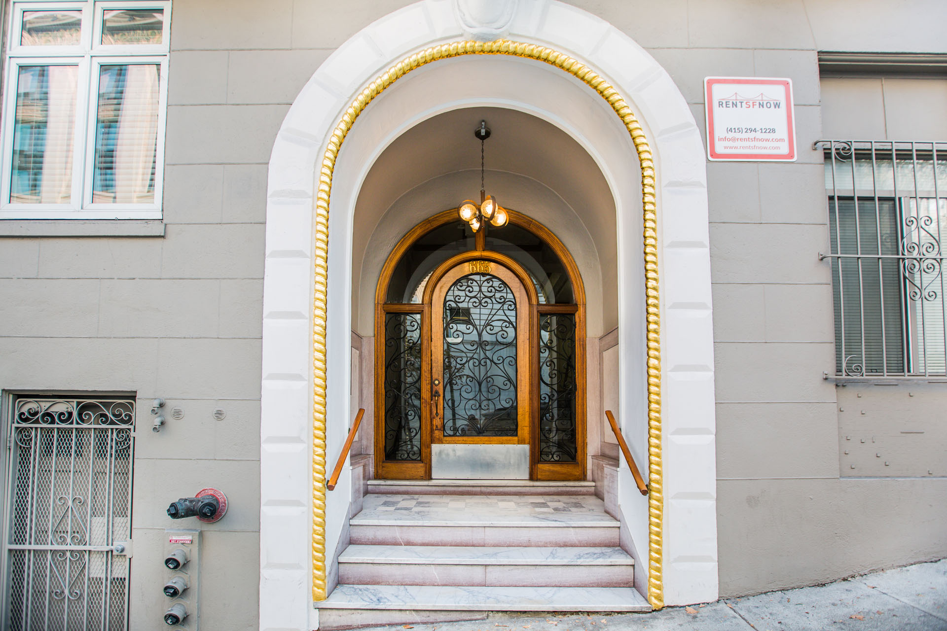 A building with a brown door and a sign that says "Rent now".